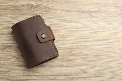 Leather business card holder on wooden table, top view. Space for text