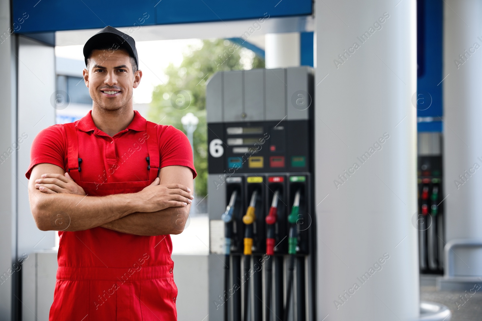 Photo of Worker in uniform at modern gas station