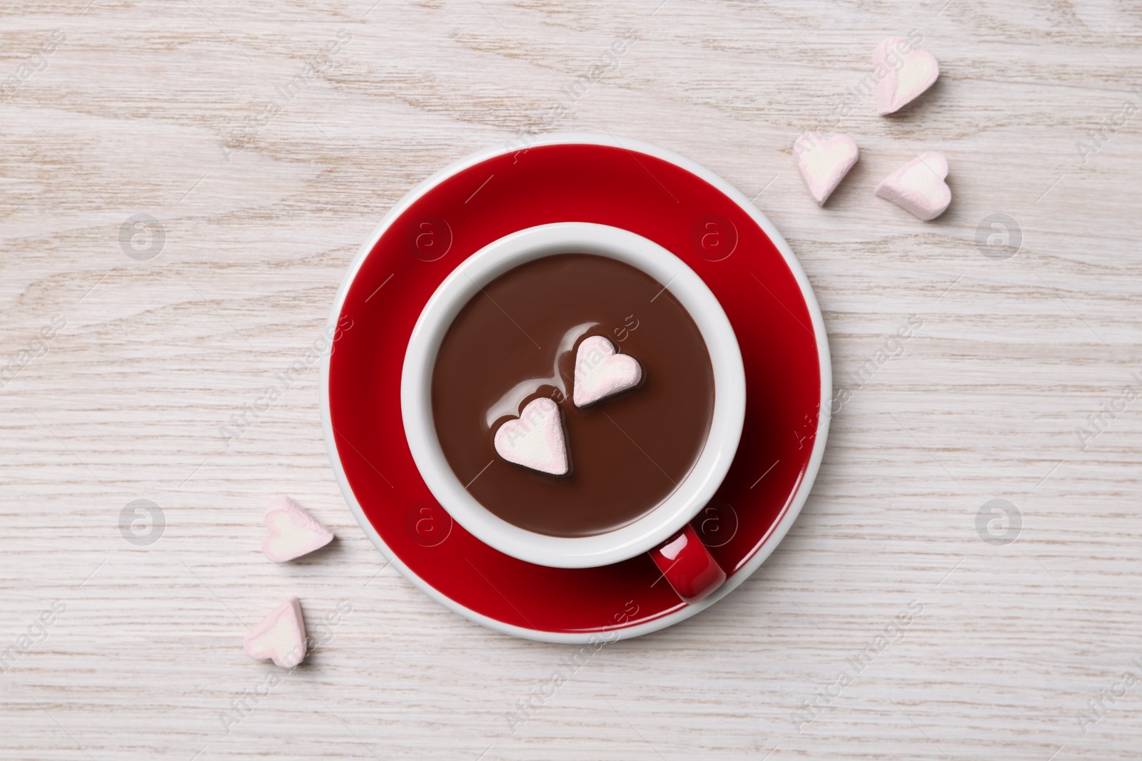 Photo of Cup of hot chocolate with heart shaped marshmallows on white wooden table, flat lay