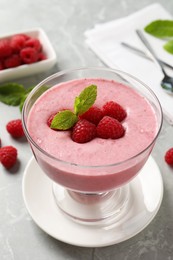 Photo of Delicious raspberry mousse with mint on grey marble table