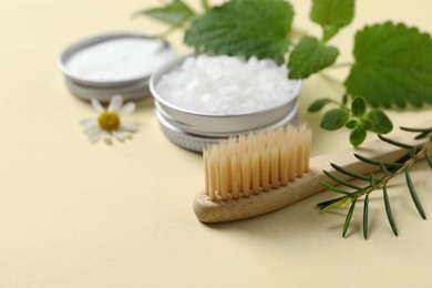 Bamboo toothbrush and herbs on beige background, closeup. Space for text