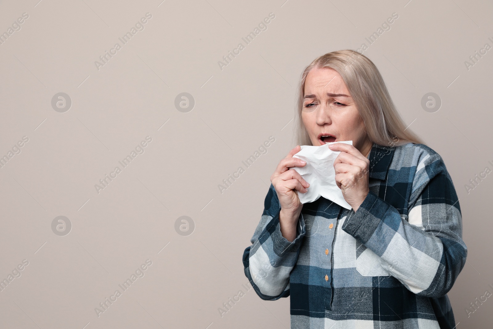 Photo of Sick mature woman on beige background, space for text. Dangerous virus