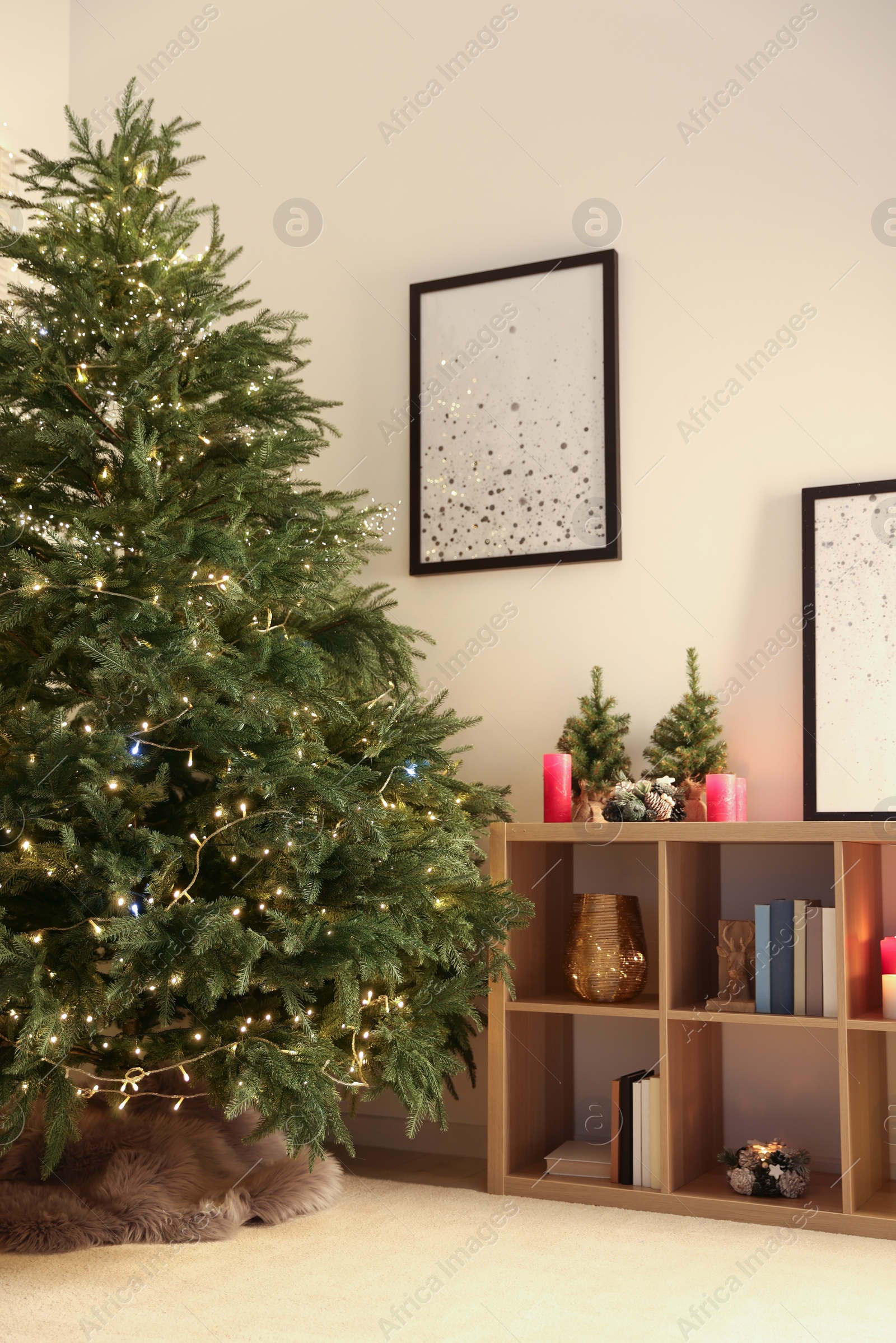 Photo of Beautiful Christmas tree with golden lights in living room