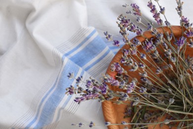 Photo of Bowl with beautiful lavender flowers on tablecloth, top view. Space for text