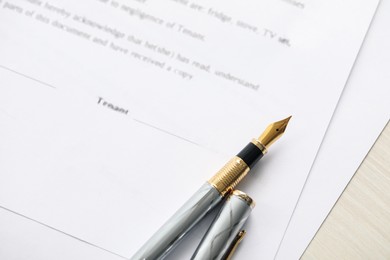 Photo of Fountain pen and documents on wooden table, above view. Notary services