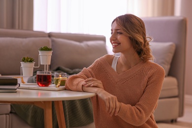 Photo of Beautiful young woman relaxing at home. Cozy atmosphere