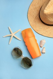 Flat lay composition with bottle of sunscreen on light blue background