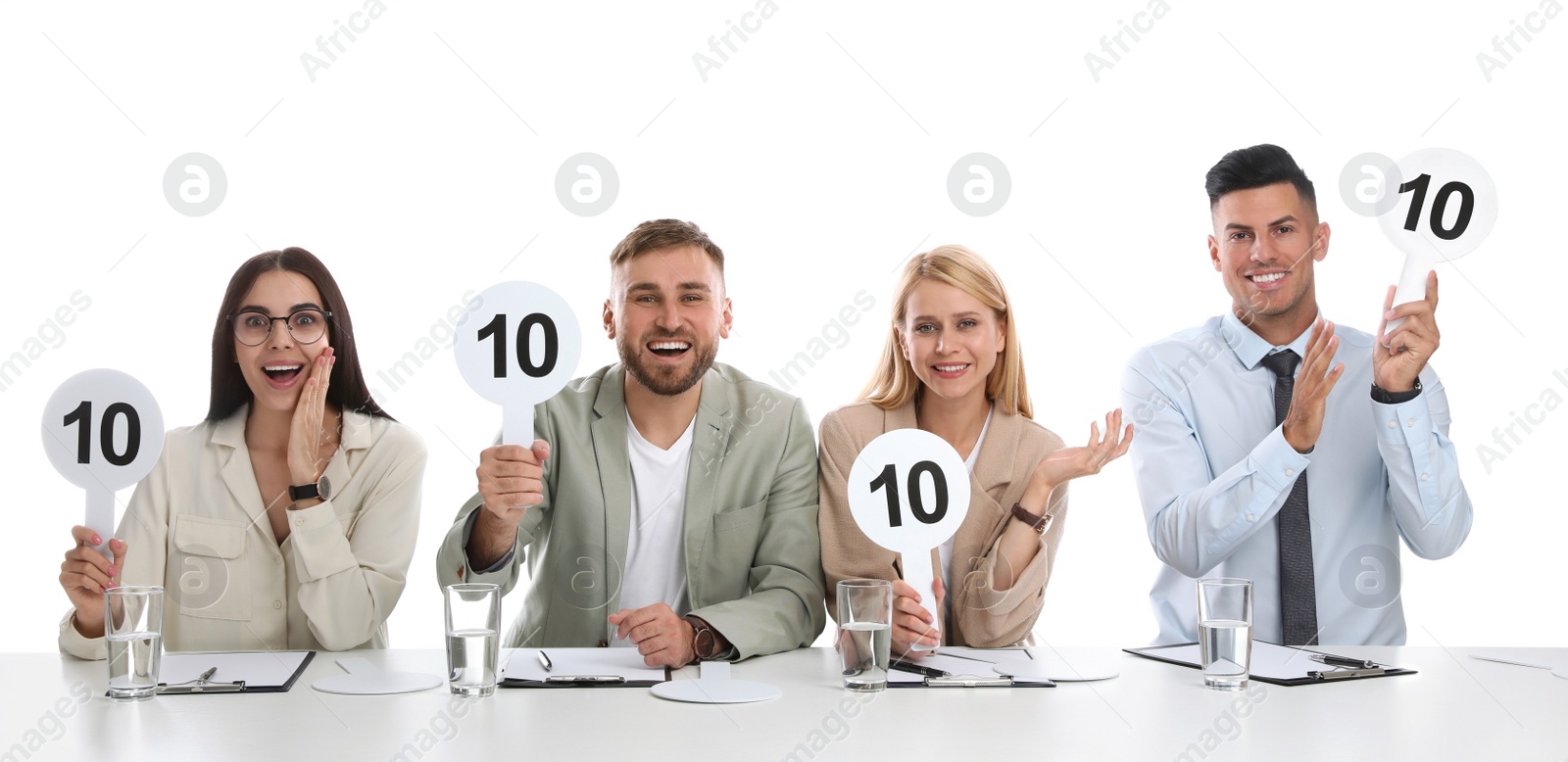 Photo of Panel of judges holding signs with highest score at table on white background