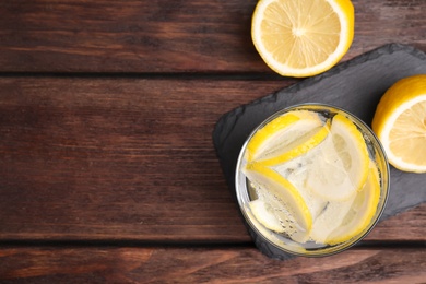 Soda water with lemon slices on wooden table, flat lay. Space for text