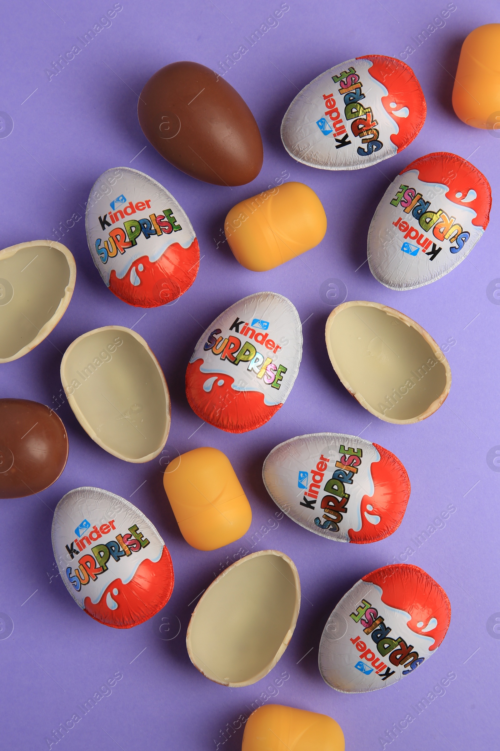 Photo of Sveti Vlas, Bulgaria - June 29, 2023: Kinder Surprise Eggs and plastic capsules on violet background, flat lay