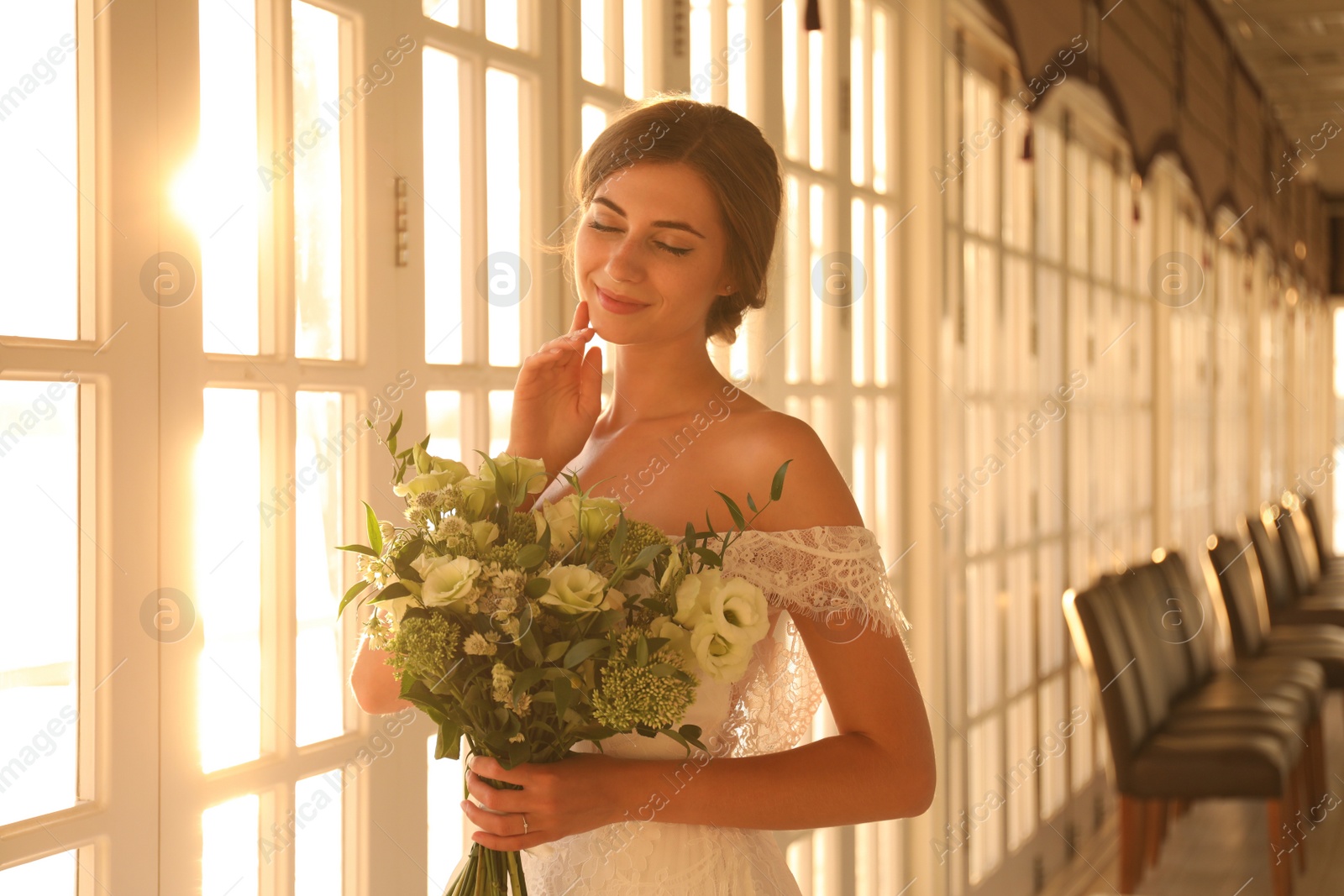 Photo of Gorgeous bride in beautiful wedding dress with bouquet in restaurant