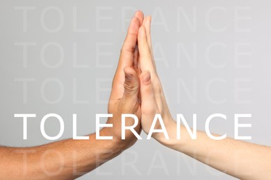 Image of Tolerance, support and cooperation concept. People of different races giving high five on light grey background, closeup