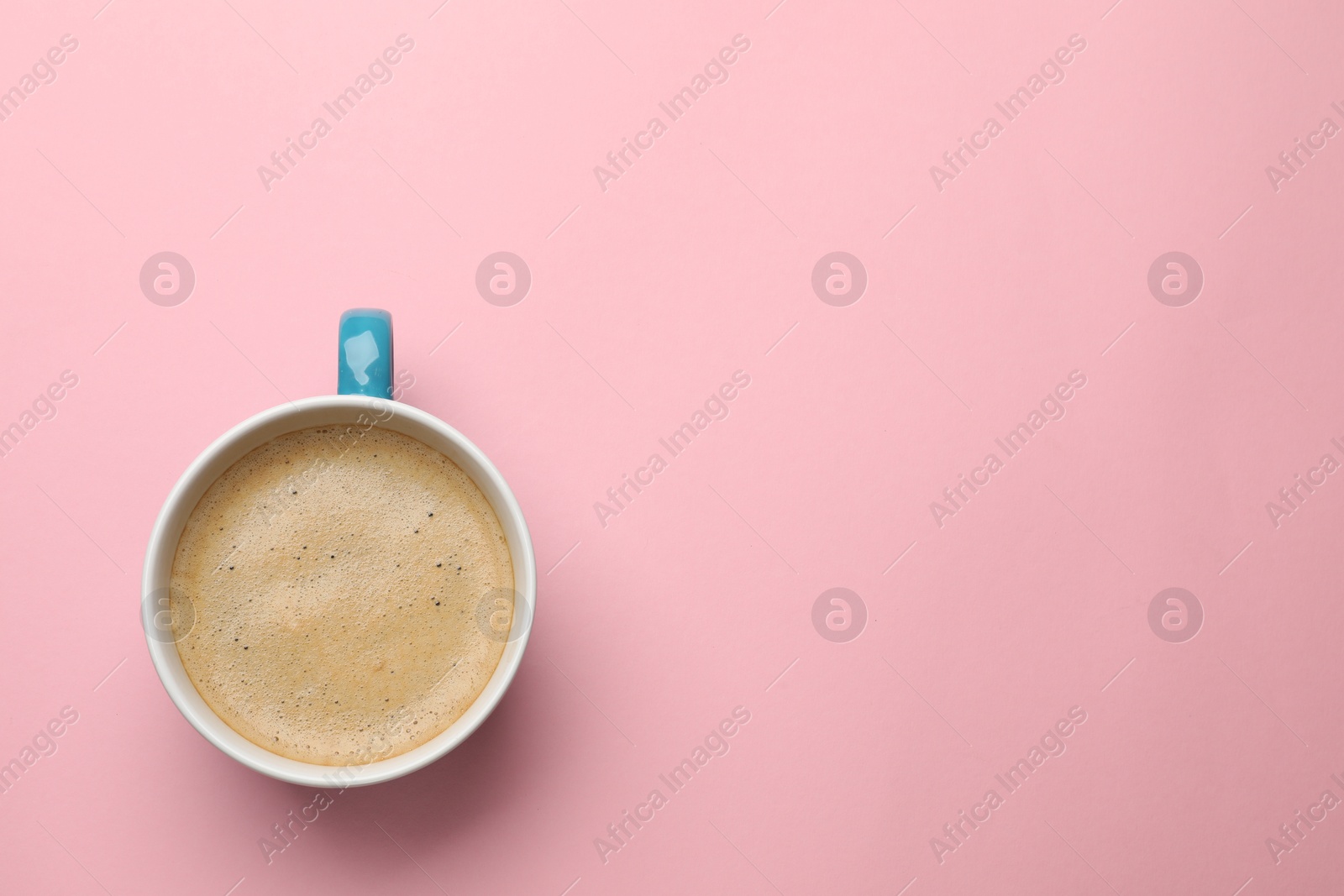 Photo of Fresh coffee in cup on pink background, top view. Space for text