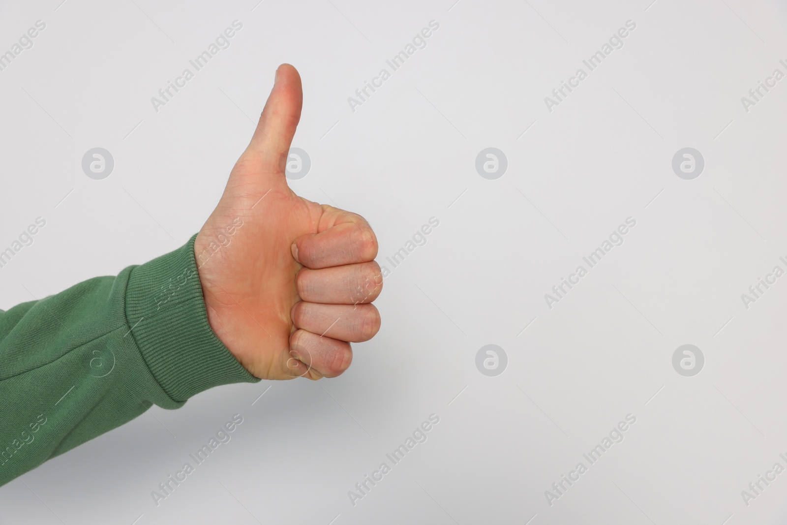 Photo of Man showing thumb up on white background, closeup. Space for text