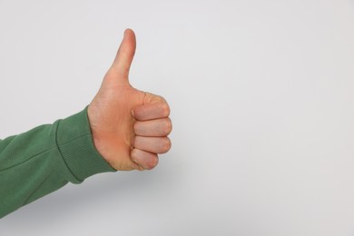 Man showing thumb up on white background, closeup. Space for text