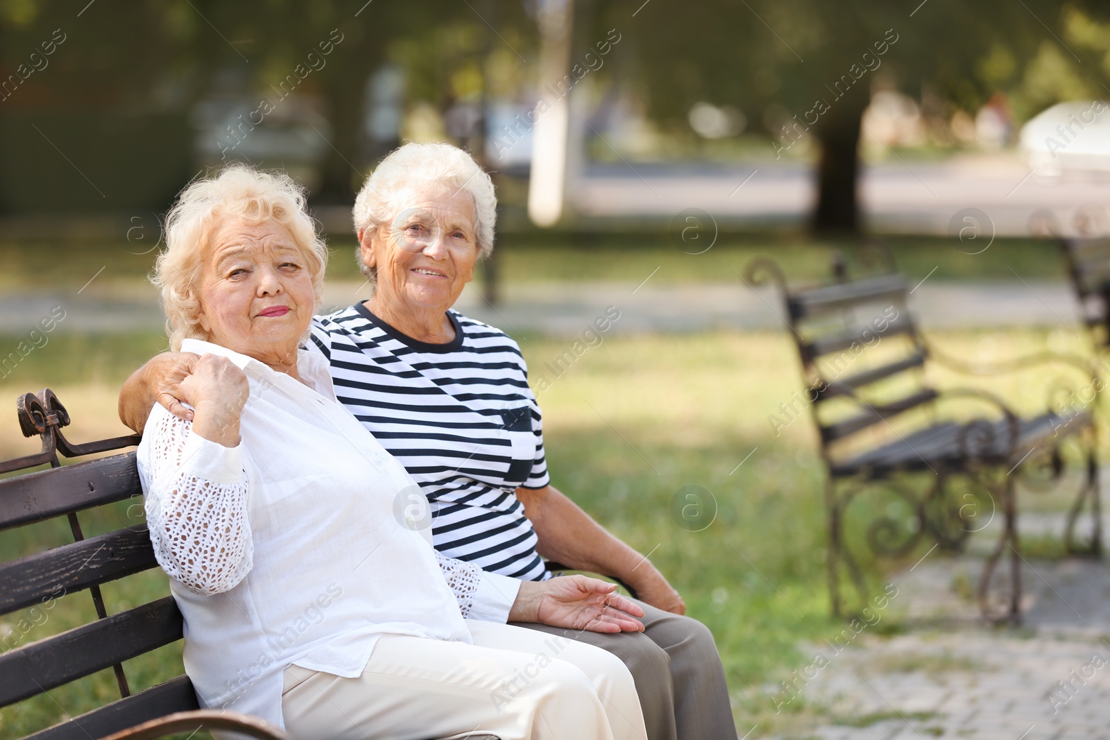 Photo of Elderly women resting on bench in park