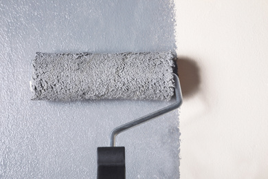 Photo of Painting beige wall with grey dye, closeup view