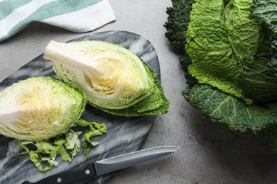 Photo of Whole and cut savoy cabbages on grey table, flat lay