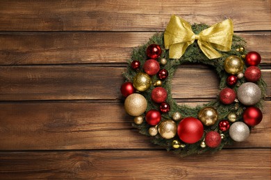 Photo of Beautiful Christmas wreath with festive decor on wooden background. Space for text