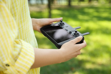 Woman holding new modern drone controller outdoors, closeup of hands