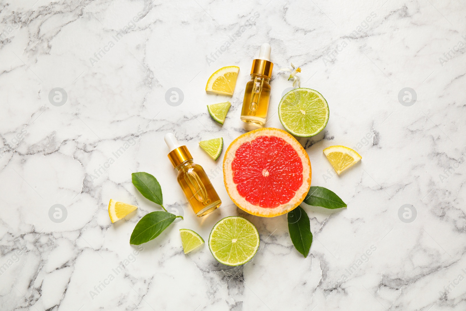 Photo of Flat lay composition with bottles of citrus essential oil on white marble background