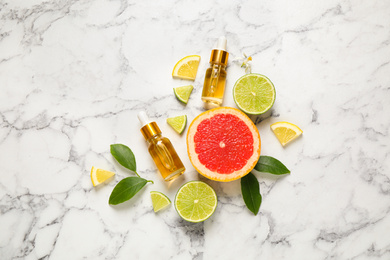 Photo of Flat lay composition with bottles of citrus essential oil on white marble background