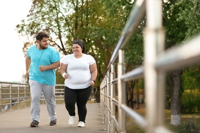 Overweight couple running together in park