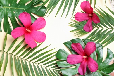 Flat lay composition with tropical leaves and Hibiscus flowers on beige background