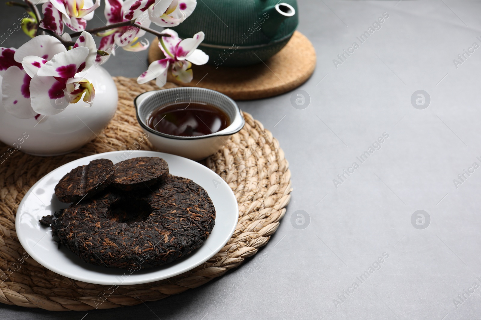 Photo of Composition with aromatic pu-erh tea on light grey table. Space for text