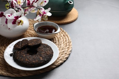 Composition with aromatic pu-erh tea on light grey table. Space for text