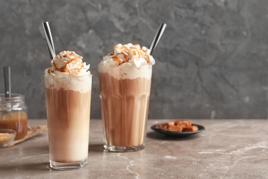 Photo of Glasses with delicious caramel frappe on table