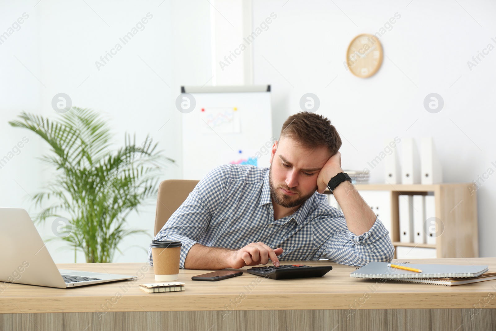 Photo of Lazy young office employee procrastinating at workplace