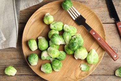 Photo of Fresh Brussels sprouts on wooden table, flat lay