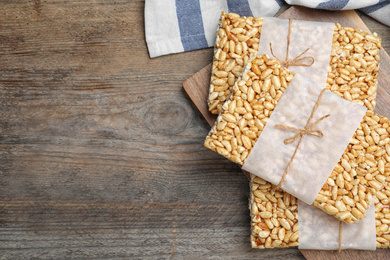 Photo of Delicious rice crispy treats on wooden table, top view. Space for text