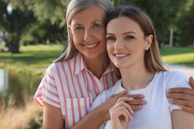 Family portrait of happy mother and daughter in park