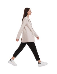 Photo of Beautiful businesswoman in suit walking on white background