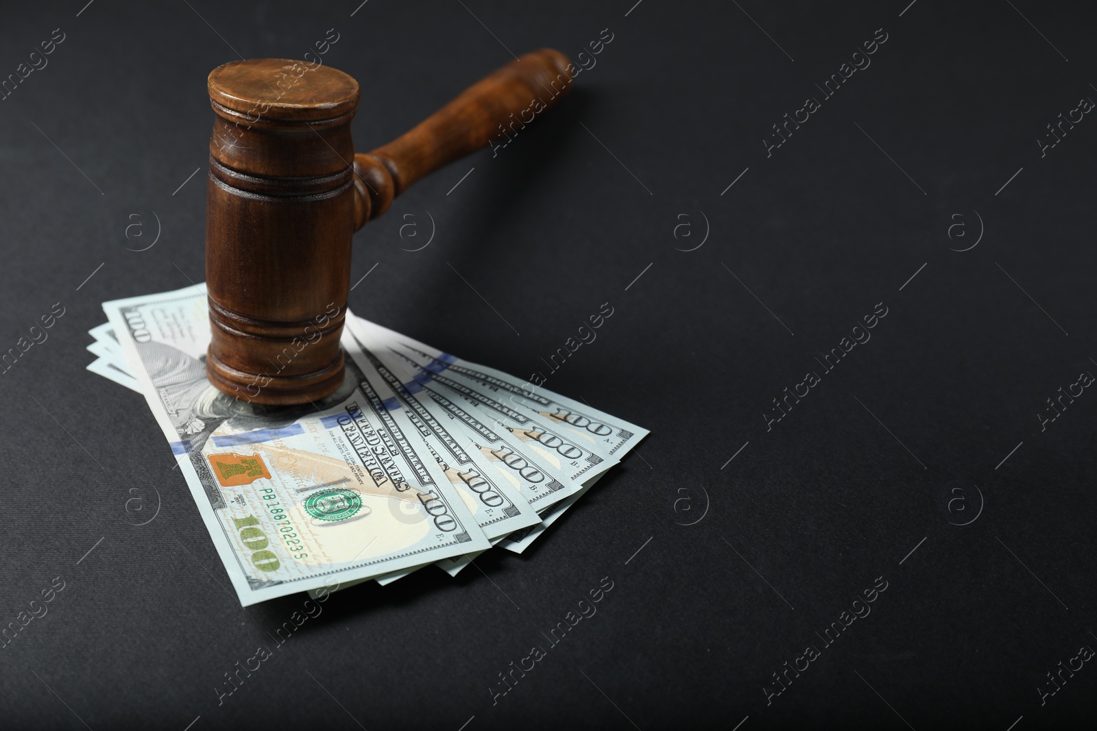 Photo of Law gavel with dollars on grey table, space for text