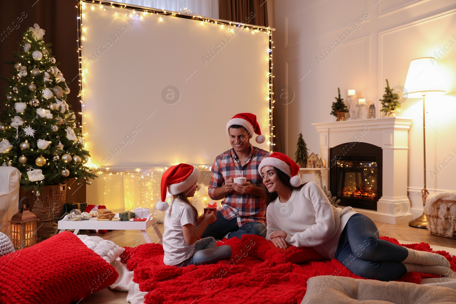 Photo of Father and daughter near video projector screen at home. Cozy Christmas atmosphere