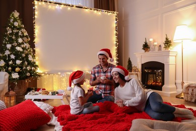 Father and daughter near video projector screen at home. Cozy Christmas atmosphere