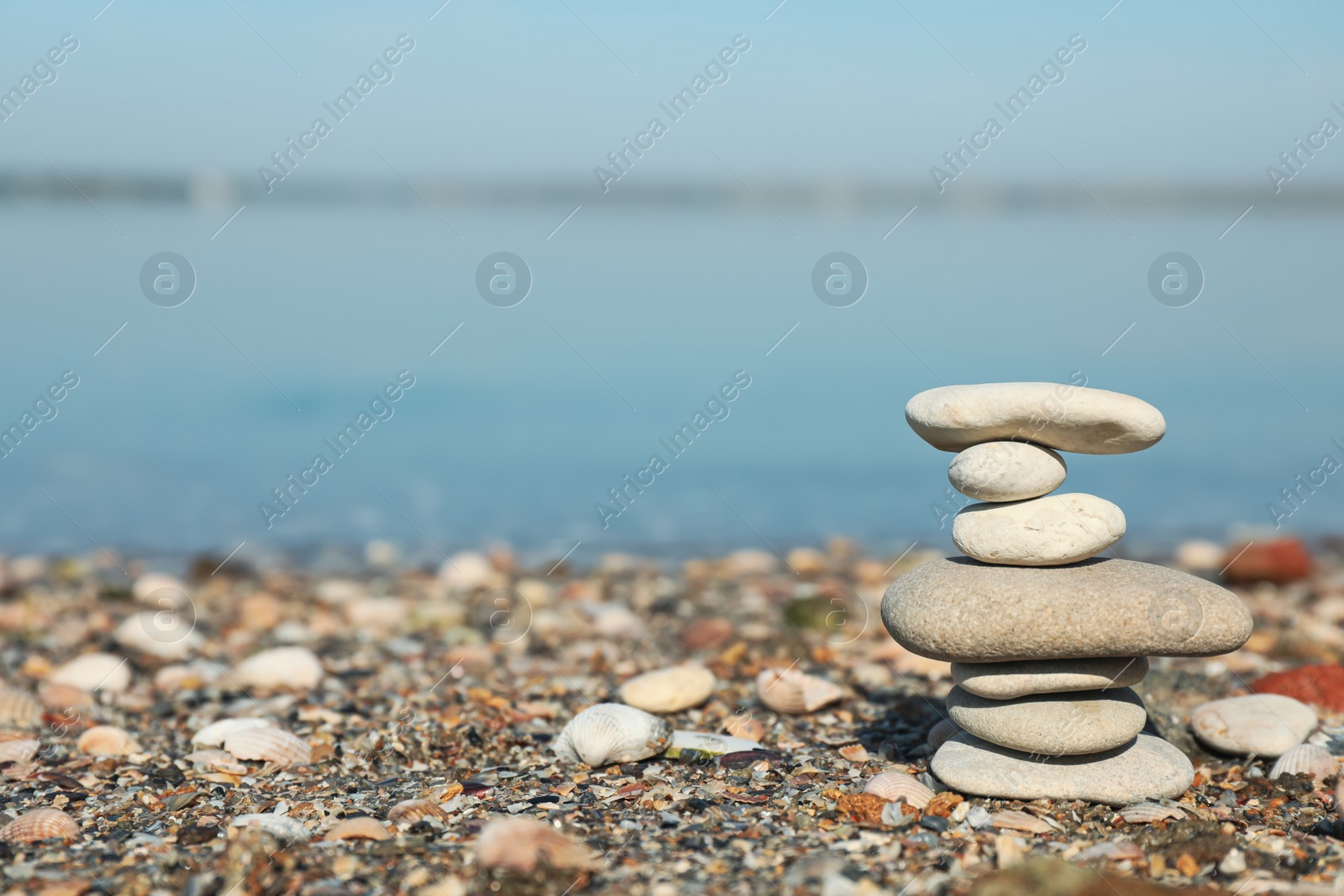 Photo of Stack of stones on beach, space for text. Harmony and balance concept