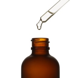 Photo of Dripping oil from pipette into glass bottle isolated on white, closeup