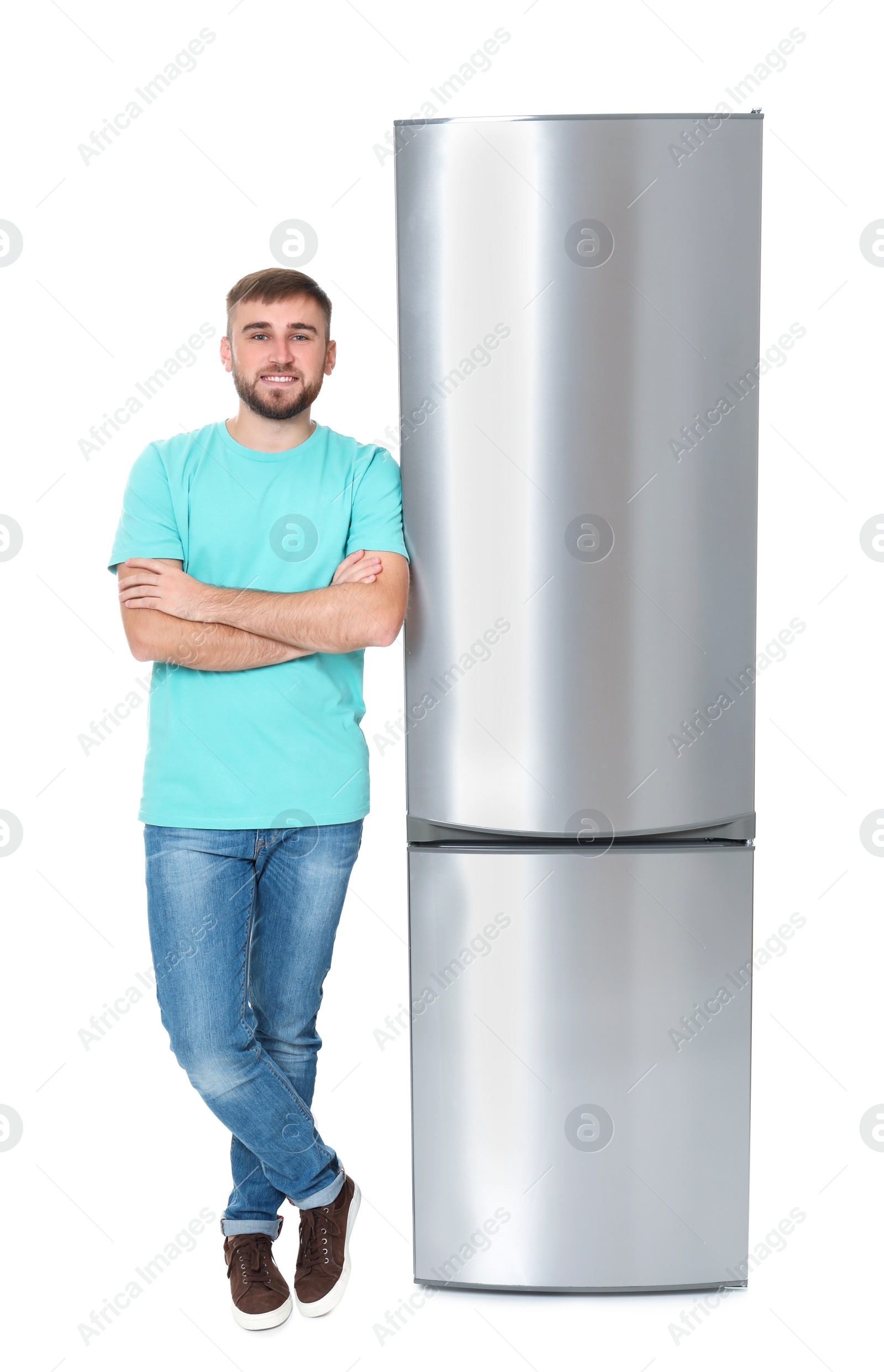 Photo of Young man near closed refrigerator on white background