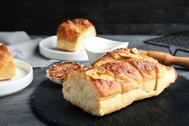 Slate plate with homemade garlic bread on table. Space for text