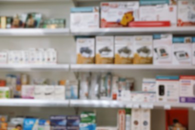 Photo of Blurred view of shelves with pharmaceuticals in modern drugstore
