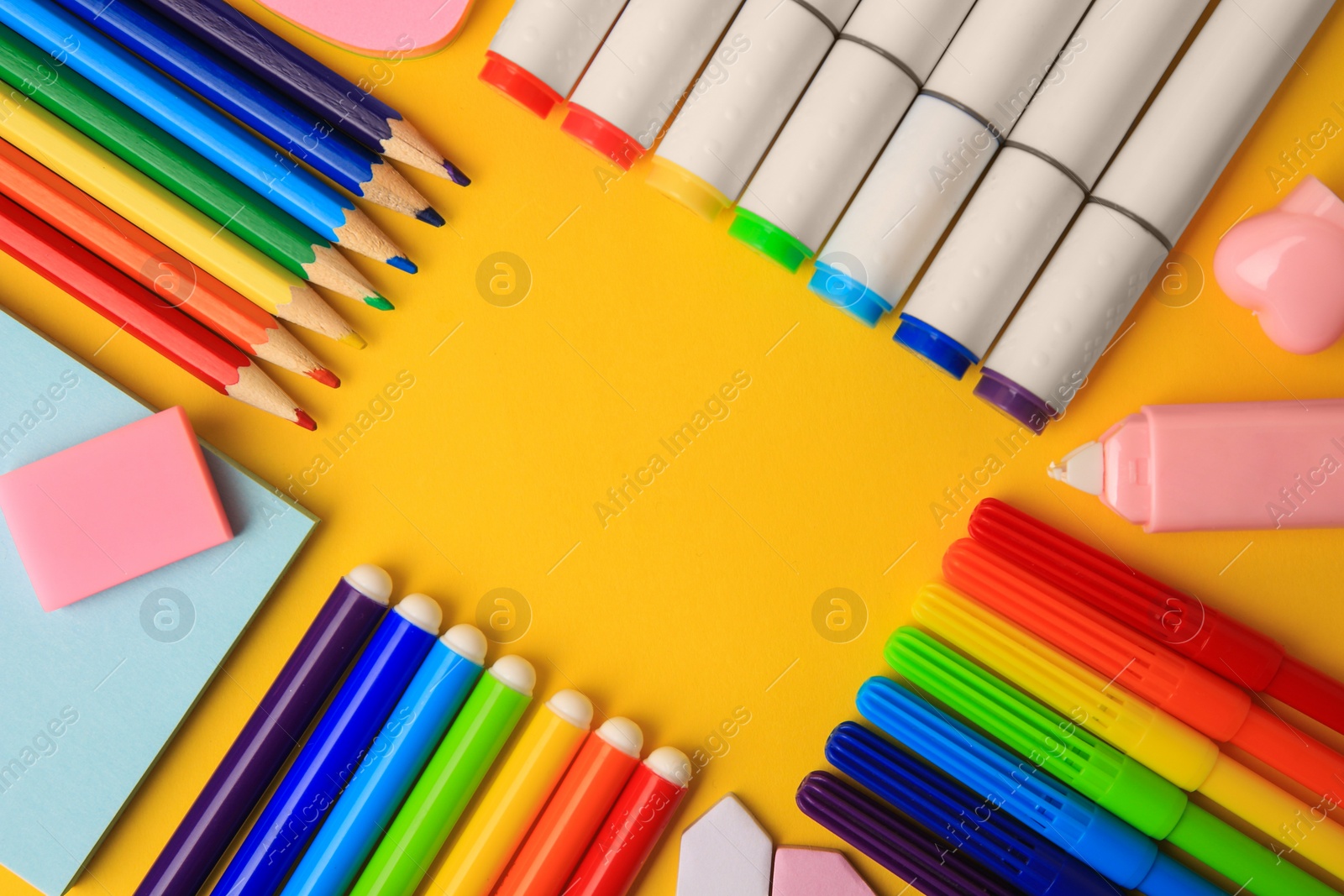 Photo of Frame of different school stationery on yellow background, flat lay with space for text. Back to school