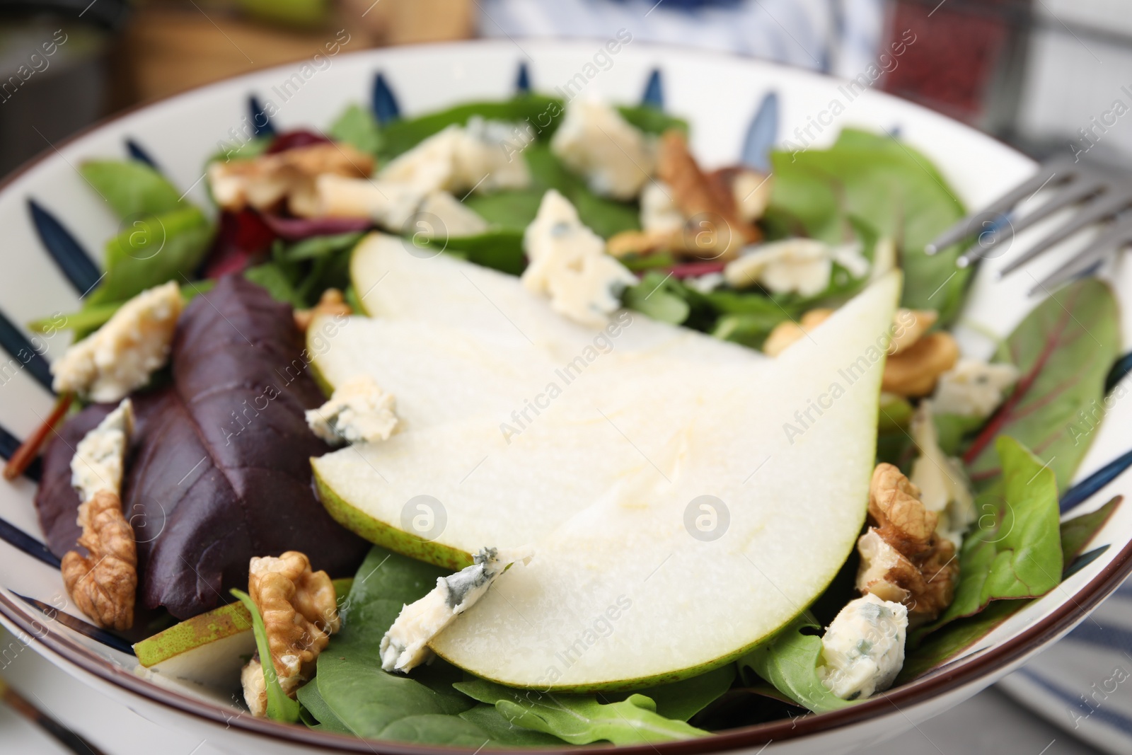 Photo of Delicious pear salad in bowl, closeup view