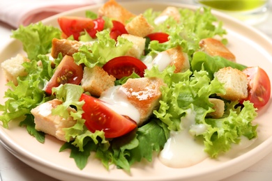 Photo of Delicious fresh Caesar salad on plate, closeup