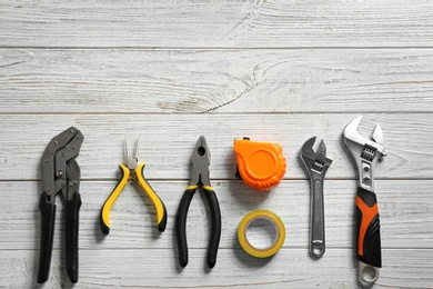 Flat lay composition with plumber's tools and space for text on wooden background