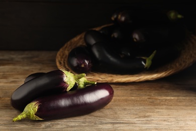 Many raw ripe eggplants on wooden table