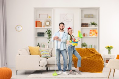 Photo of Spring cleaning. Couple with detergents and mop in living room